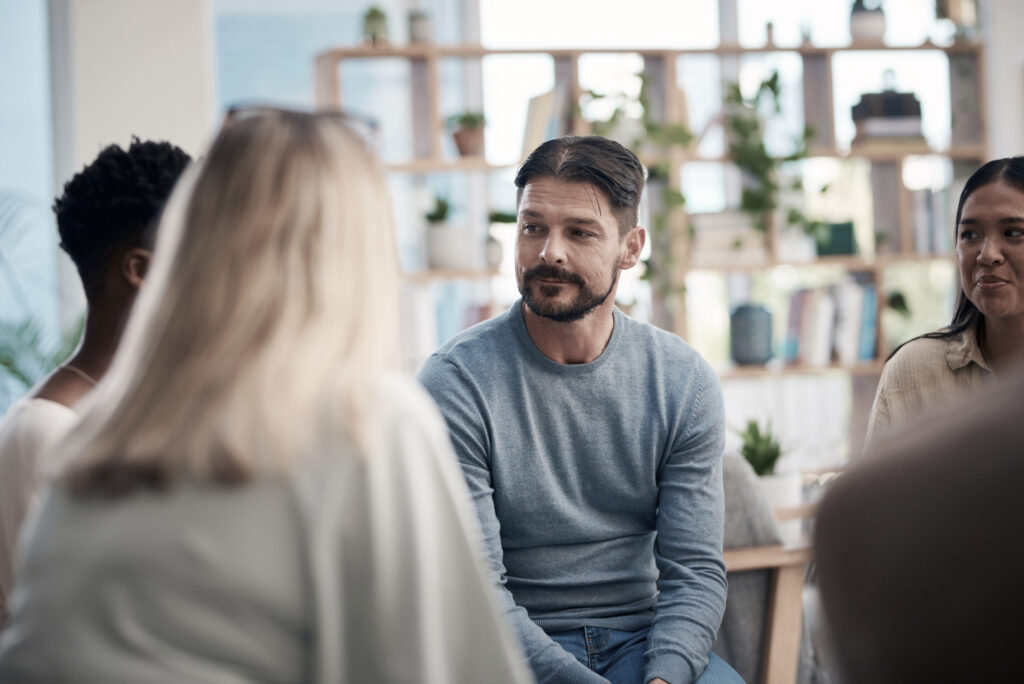 A group of clients in a group cognitive-behavioral therapy (CBT) session at a Half-Day Treatment Program at Pillars Health Group.