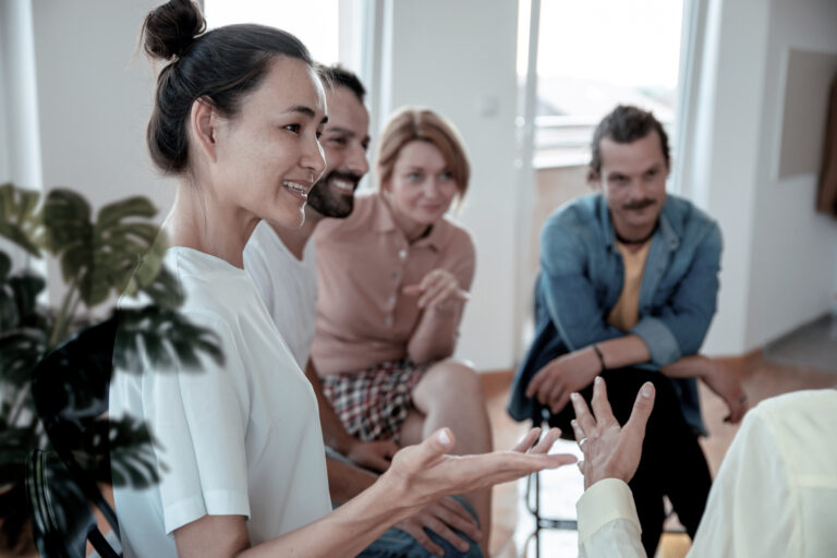 A woman participating in a group therapy session for opioid addiction treatment at Pillars Health Group.