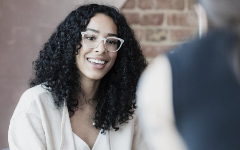 A woman smiling as she discusses her mental health with a therapist at Pillar Health Group in ME