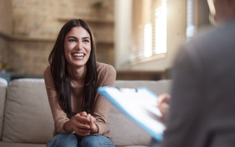 a happy young woman in therapy at Pillars Health Group