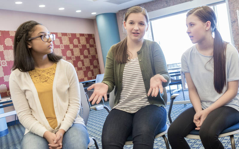 A young girl in a group therapy session for teen anxiety disorder at Pillars Health Group's teen mental health center in Concord, MA.
