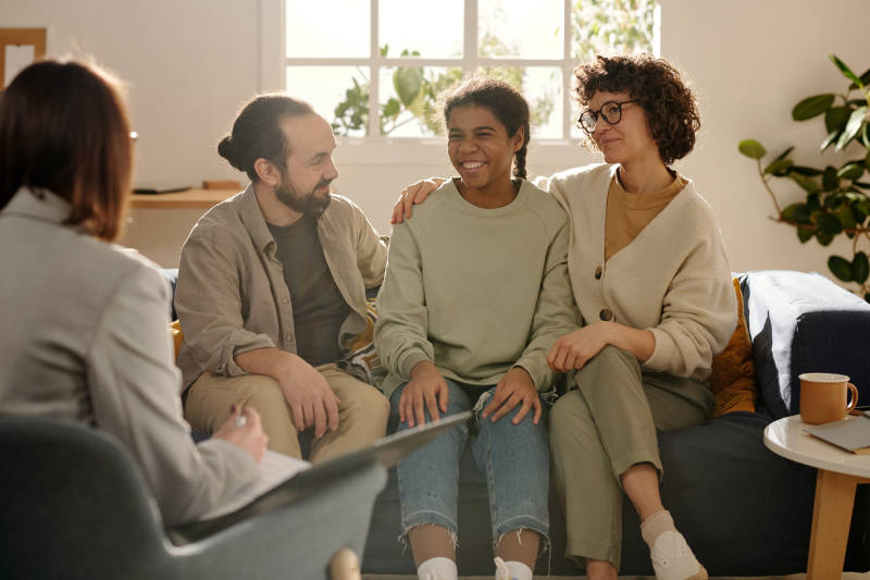 A young teen getting family support during her therapy session.