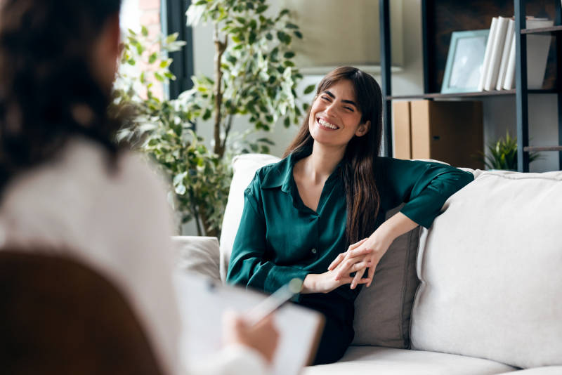 A woman in a therapy session learning about the differences between CBT and DBT.