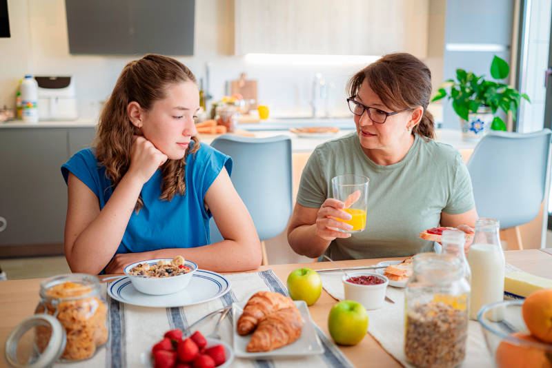 A teenage girl learning about eating disorders from her mother.